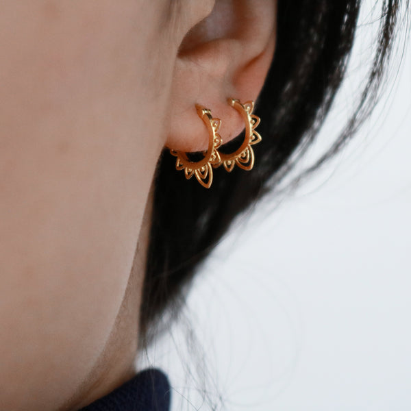 Stylr mixed-metal layering: gold hoop earrings paired with silver stack