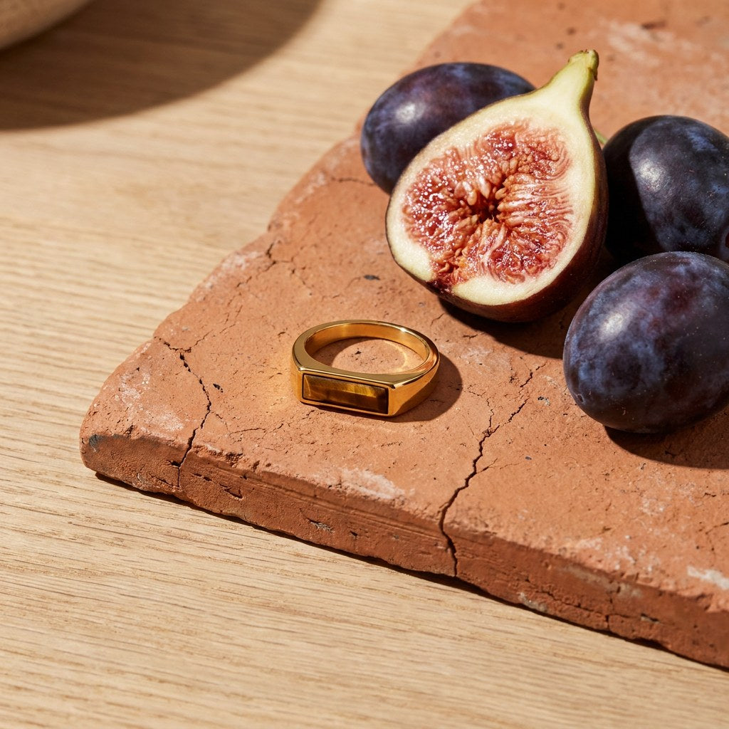 Bar Tigers Eye Ring on a weathered terracotta tile with a cut fig and dark plums