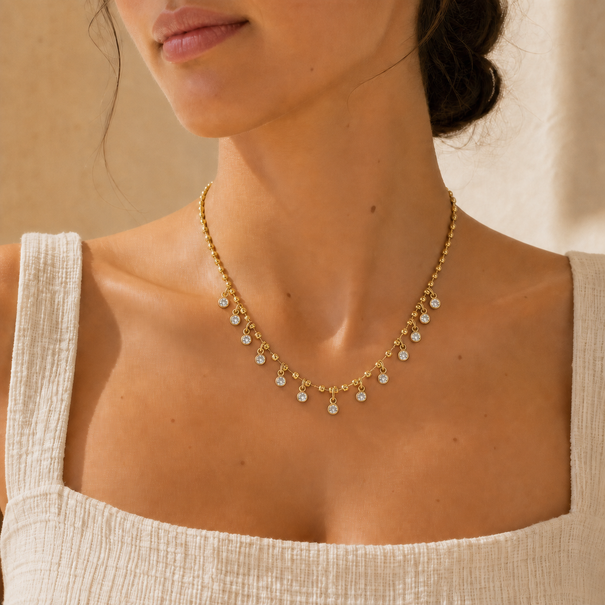 Crystal Fringe Necklace worn at the collarbone, gold-plated bead chain with 13 bezel-set clear crystals