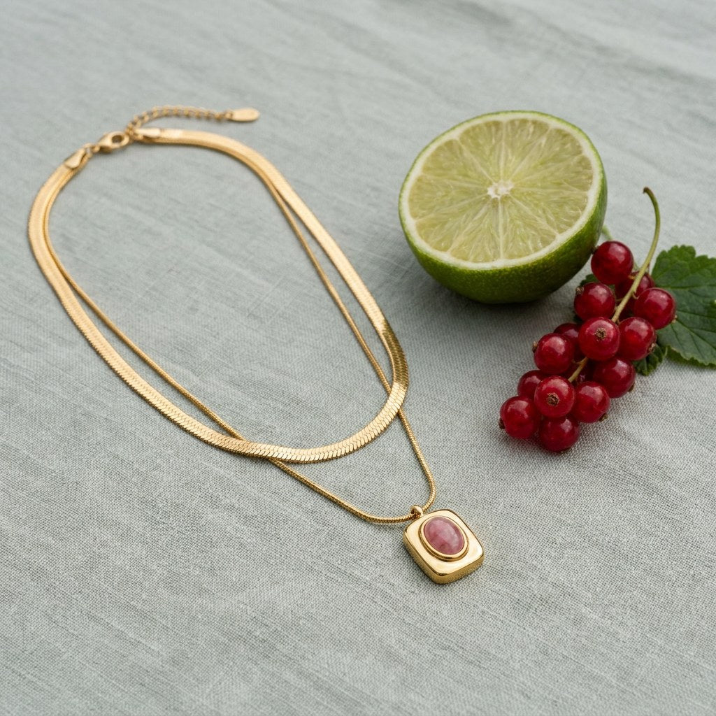 Eve Layered Necklace on pale grey-green linen beside a halved lime and red currants