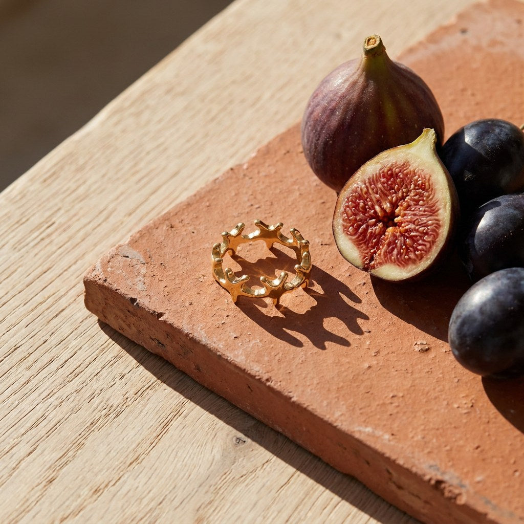 Gold Plated Starfish Band Ring on a weathered terracotta tile with a cut fig and dark plums