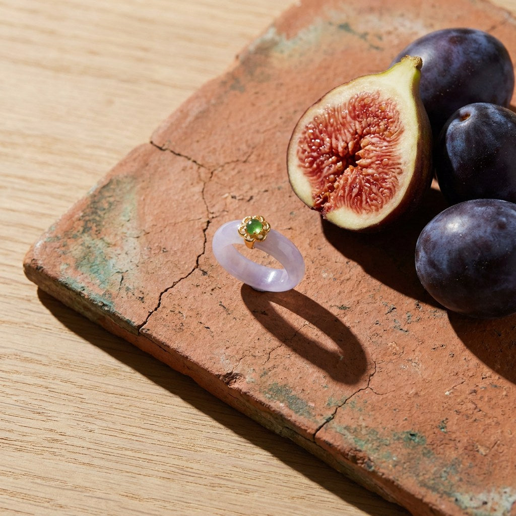 Lyla White Jade Band Ring on a weathered terracotta tile with a cut fig and dark plums