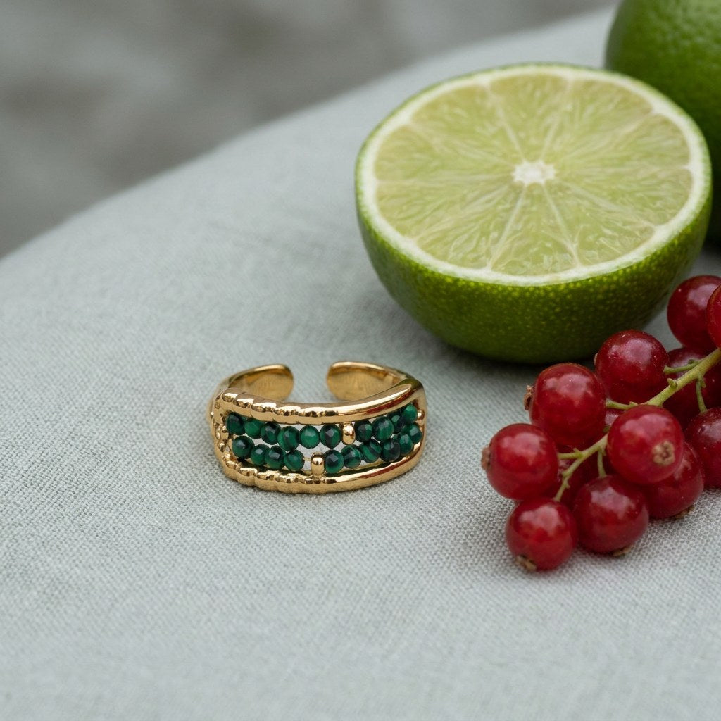 Malachite Bead Ring on pale grey-green linen beside a halved lime and red currants