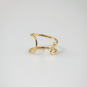 Gold ring with a small diamond on a light gray background