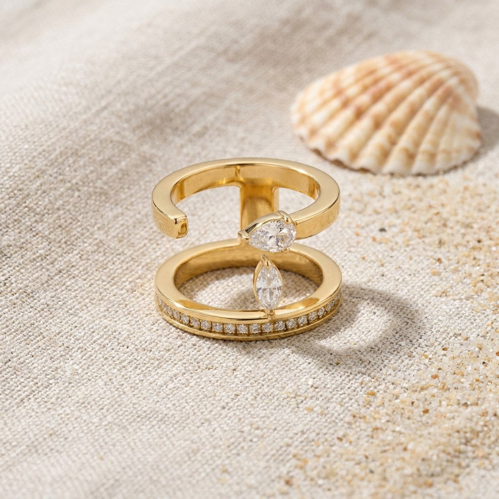 Negative Space Ring on raw linen beside a scallop shell and a scatter of fine sand