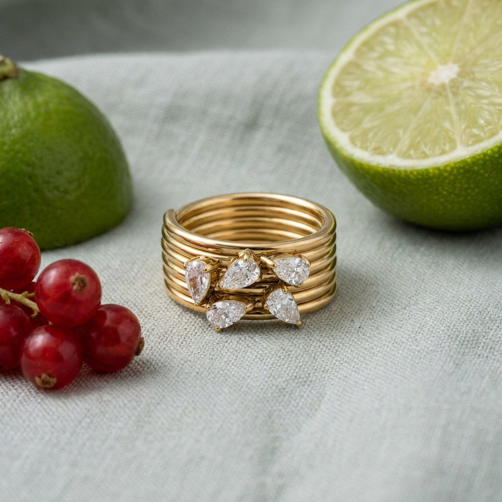 Pear Cluster Ring on pale grey-green linen beside a halved lime and red currants