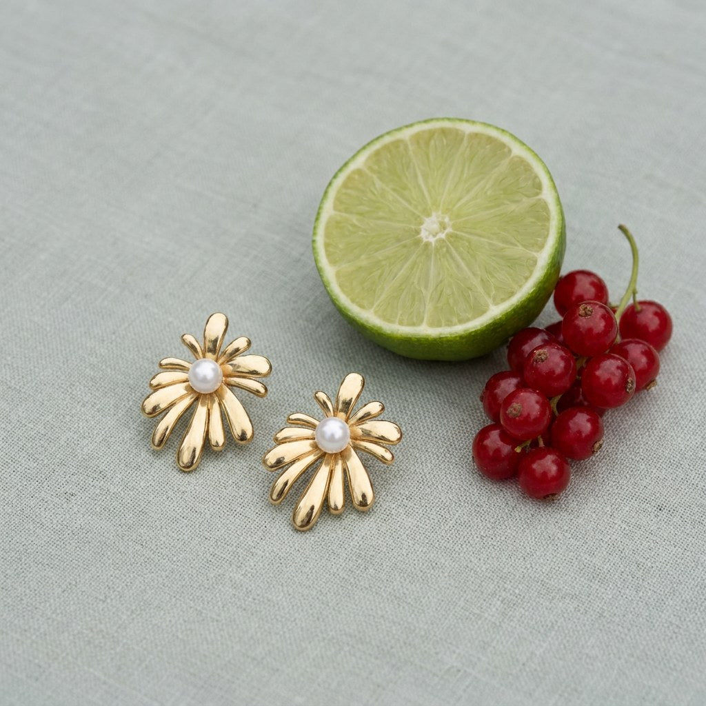 Sunburst Pearl Stud Earrings on pale grey-green linen beside a halved lime and red currants