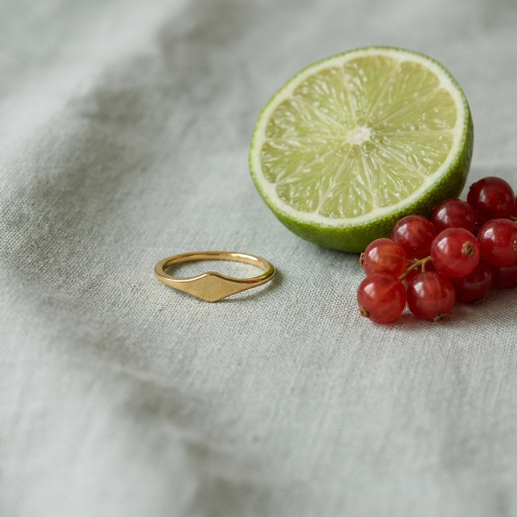 Tarnish on pale grey-green linen beside a halved lime and red currants