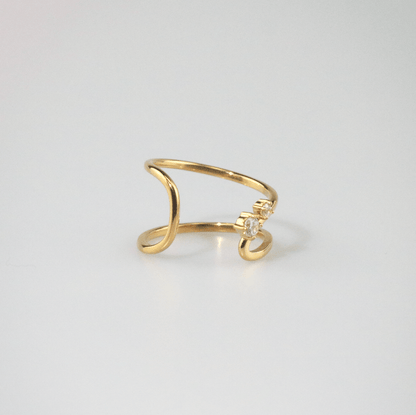 Gold ring with a small diamond on a light gray background